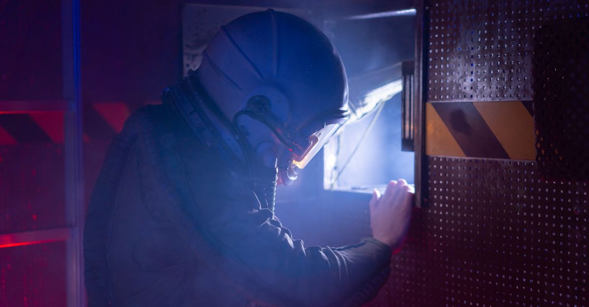 A woman astronaut in a space suit exploring a futuristic spacecraft interior with atmospheric lighting.